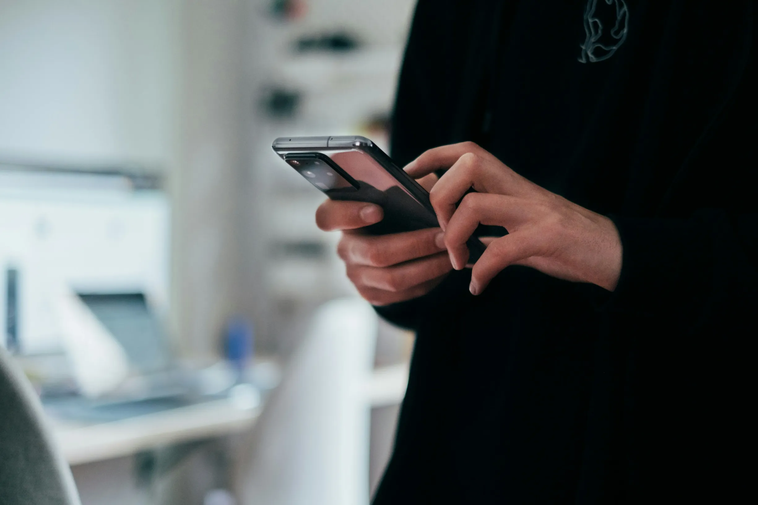 Mann nutzt sein Smartphone im Büro